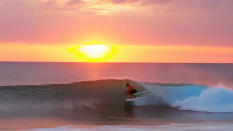 surfer riding a wave during a vibrant sunset