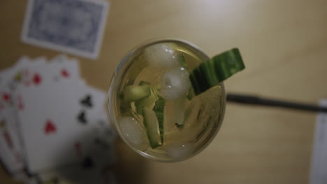 Top-down-shot-of-a-glass-of-sangria-on-a-table-next-to-a-deck-of-playing-cards