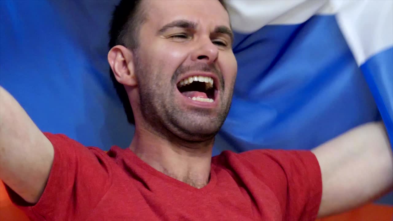 fanático ruso celebrando mientras sostiene la bandera de rusia en cámara lenta,4k, de alta calidad