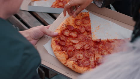 Eine-Gruppe-Von-Freunden,-Die-Auf-Dem-Dach-Pizza-Essen,-Genießen-Eine-Wochenendparty,-Hängen-Zusammen-Und-Unterhalten-Sich-Bei-Sonnenuntergang