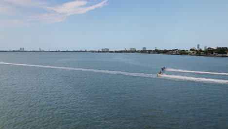 Aerial-tracking-shot-water-scooters-driving-on-the-coast-of-Miami,-Florida,-USA