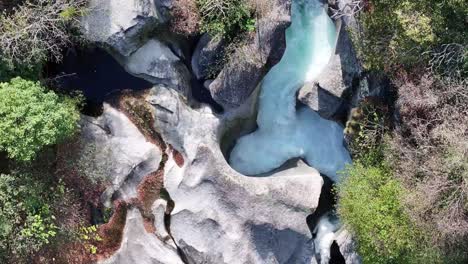 turquoise river snaking through foroglio's rocky terrain, maggiatal, tessin, switzerland - aerial top view