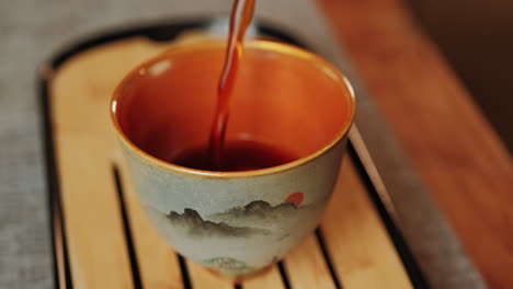 pouring tea into a beautiful ceramic cup