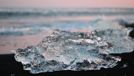 small piece of glacier ice on black sand of diamond beach, iceland