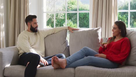 Vídeo-De-Una-Feliz-Pareja-Caucásica-Sentada-En-Un-Sofá-Y-Tomando-Café