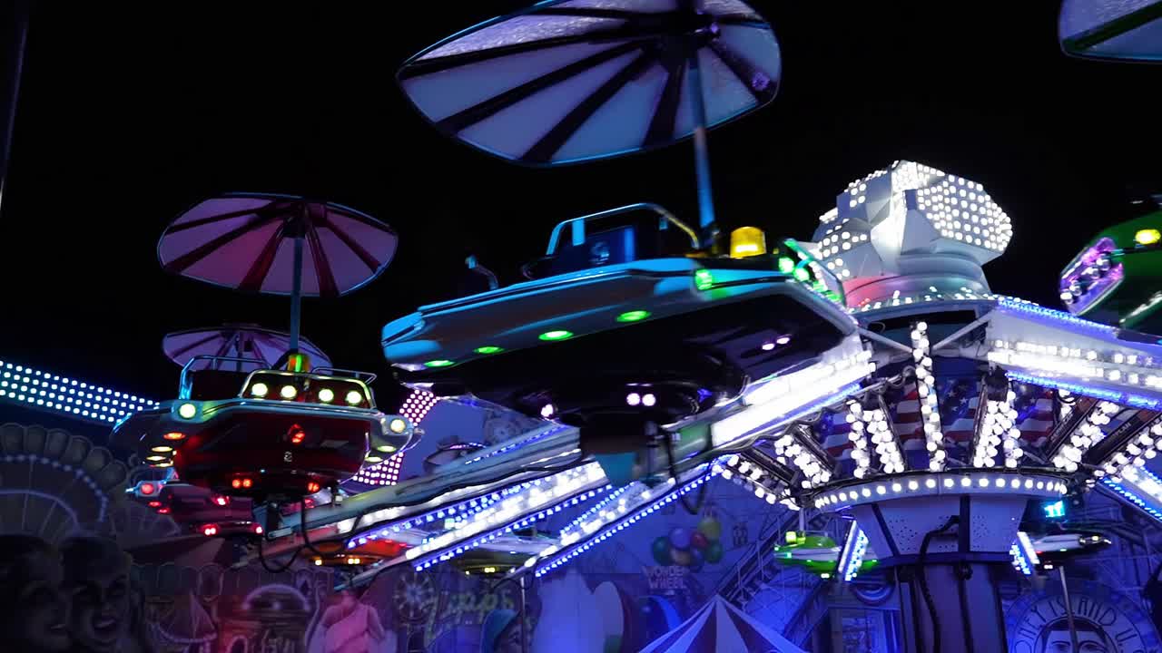 Flying saucers carousel at night in a city amusement park