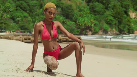 un paraíso tropical se despliega cuando una chica negra se pone un bikini rojo en una playa de arena blanca del caribe.