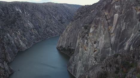 sheer granite cliffs drop to salto de aldeadavila reservoir in spain