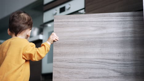 toddler exploring kitchen cabinets