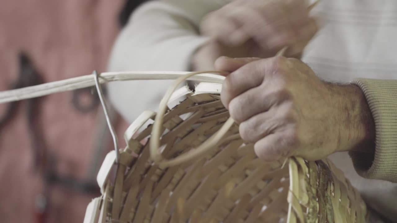 Turkish master weaves baskets from wooden sticks. 4K close-up. Craft concept.