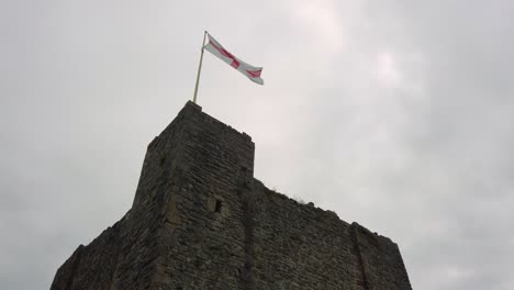 st george cross flag waving on top of gothic castle turret silhouette