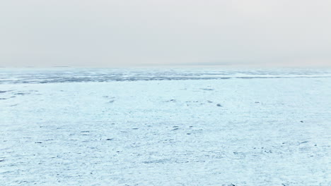 Drone's-eye-perspective-soaring-over-the-tranquil-frozen-surface-of-Lake-Michigan