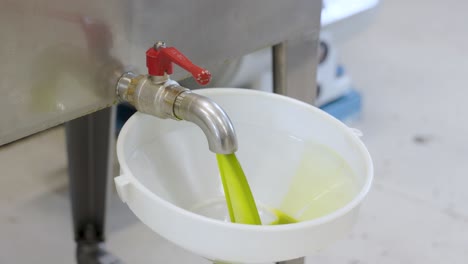 freshly pressed extra virgin olive oil that is at the end of production is being prepped for bottling and distribution located in the region of abruzzo italy during harvesting season