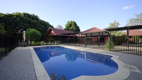 Piscina-En-Una-Finca-Rural-Con-Vistas-A-La-Zona-De-Ocio-Al-Aire-Libre-De-Una-Gran-Casa-Roja