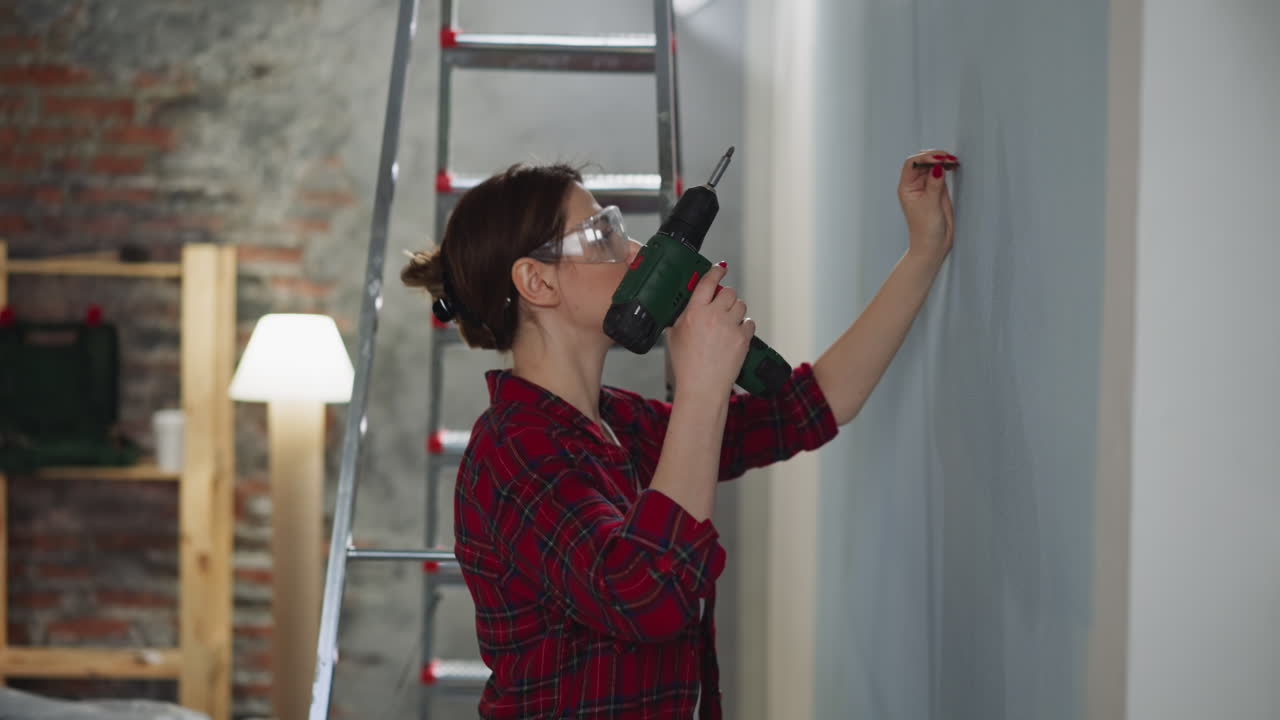 mujer con gafas se prepara para atornillar la sujeción en la habitación
