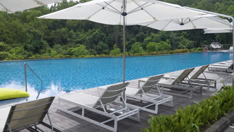 infinity pool with lounge chairs and umbrellas