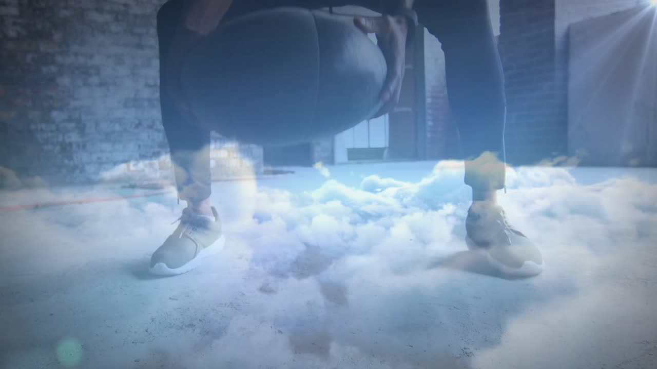 Animation of clouds over african american sportsman at gym