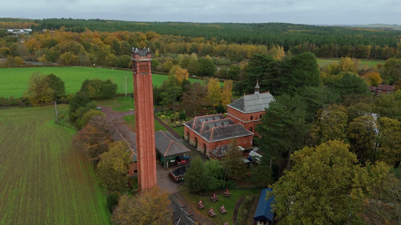 Ampia prospettiva aerea della vecchia stazione di pompaggio dell'acqua circondata dal bosco autunnale a Papplewick, vicino a Nottingham