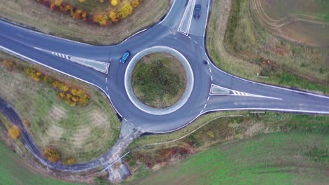 spinning top down aerial view of cars on roundabout