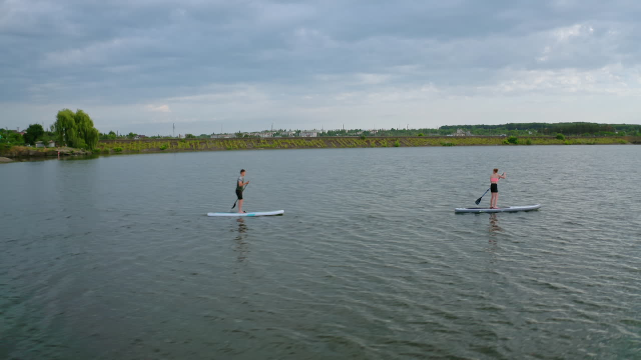 People Floating Standup Paddle Board. People standing on sup board and swims surfing on the river