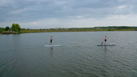 people floating standup paddle board. people standing on sup board and swims surfing on the river