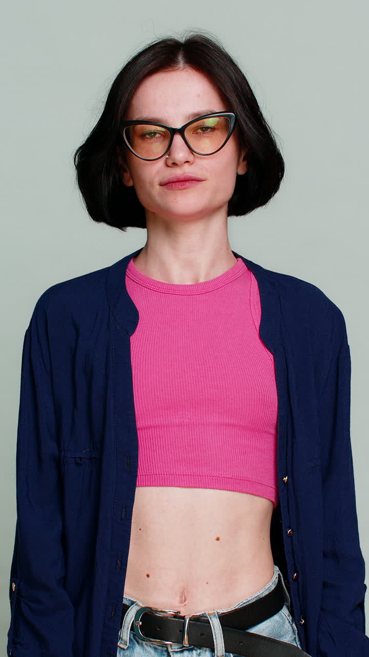 Woman making heart shape with fingers looking gently at camera expressing love affection caring