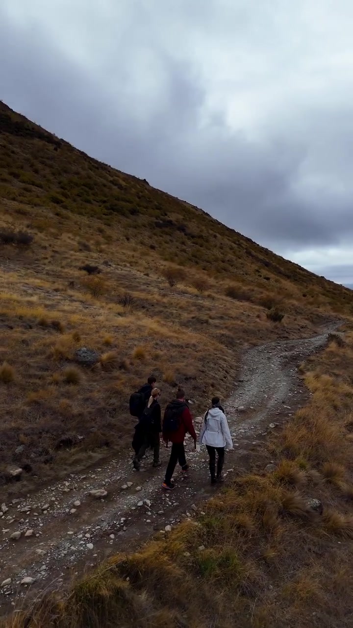Gruppo di amici in escursione lungo il Lago Tekapo in autunno, Nuova Zelanda. Vista aerea.