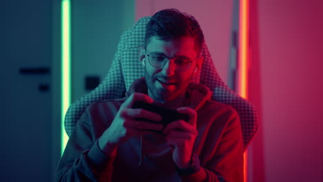 esport and video game addiction portrait of young man playing mobile game by smartphone online streaming addicted man in game world and virtual reality red and green light