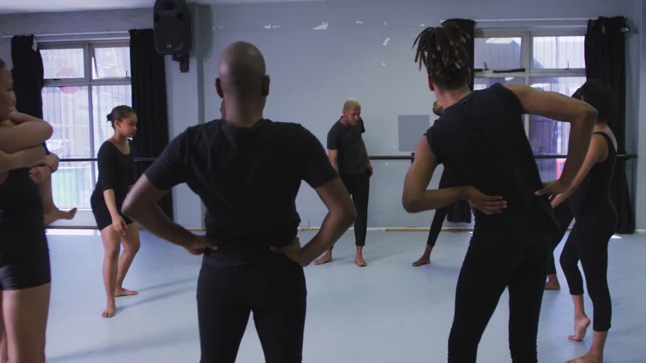 grupo multiétnico de bailarines modernos en forma masculinos y femeninos practicando una rutina de baile