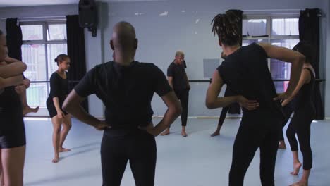 multi-ethnic group of fit male and female modern dancers practicing a dance routine