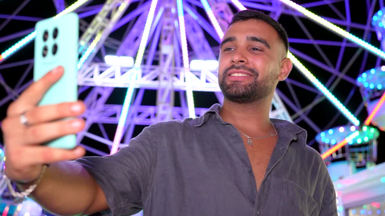Man taking a selfie at a Ferris wheel