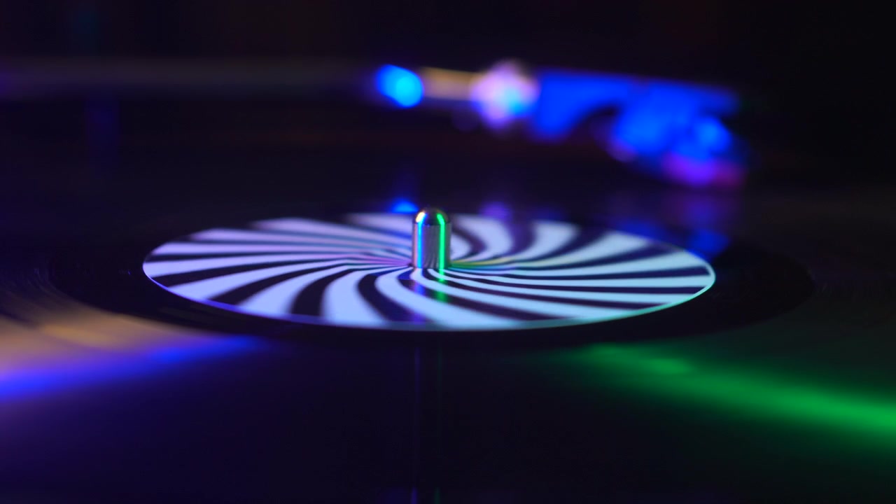 Spinning Vinyl Record on Turntable and Colorful Lights, Close Up