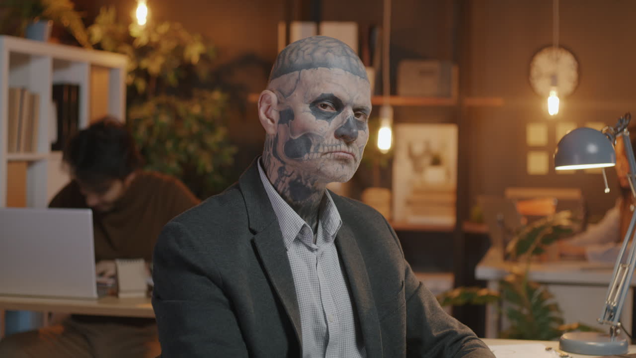 Businessman with elaborate skull tattoos in an office
