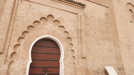 Panorámica-Hacia-Arriba-En-La-Mezquita-Koutoubia-Desde-La-Puerta-Hasta-El-Minarete-De-Marrakech,-Marruecos