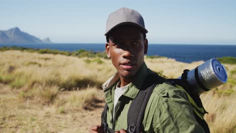 portrait of african american man hiking in countryside by the coast