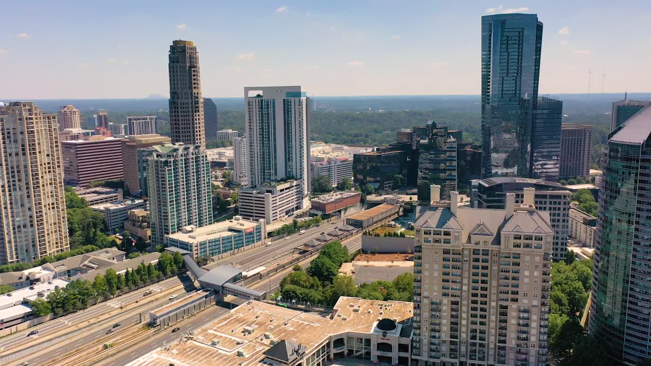 Ripresa aerea lenta su Buckhead Atlanta con auto che percorrono l'autostrada vicino alla metropolitana.