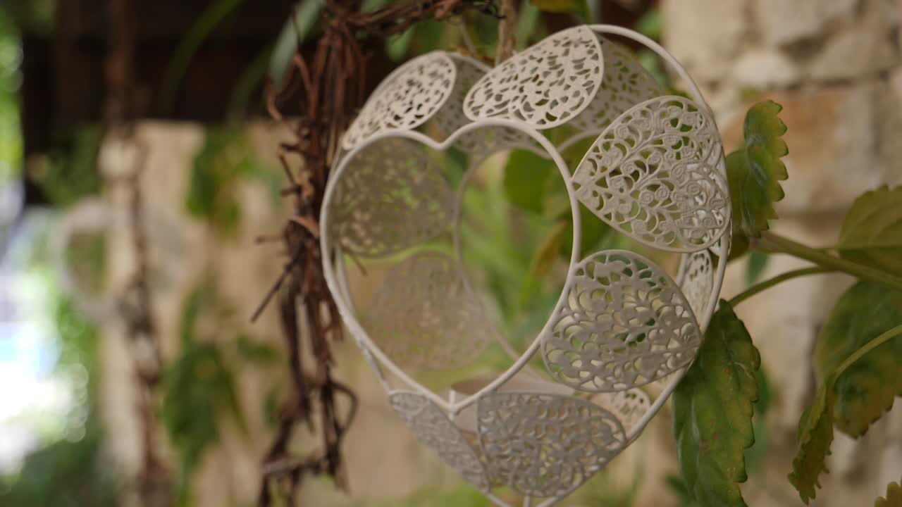 Slow close-up pan across a heart shaped wedding decoration hanging
