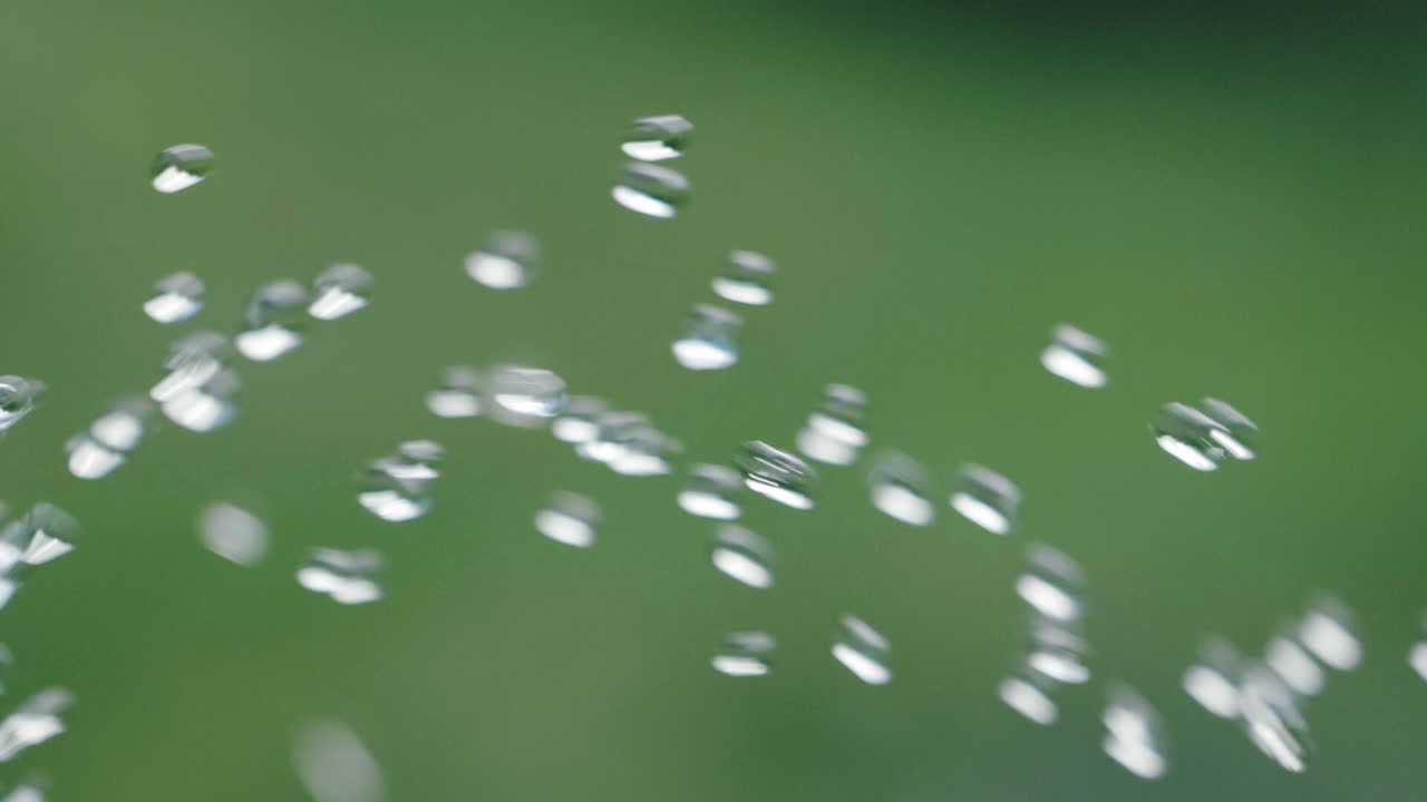 녹색 배경 - 180fps로 느린 동작으로 카메라를 통과하는 순수한 물방울