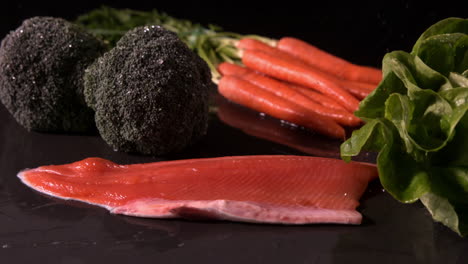 filete de trucha que cae delante de la selección de verduras