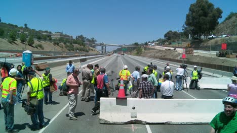 zoom out from crews working on a closed of the 405 freeway in los angles to show a crowd of onlookers