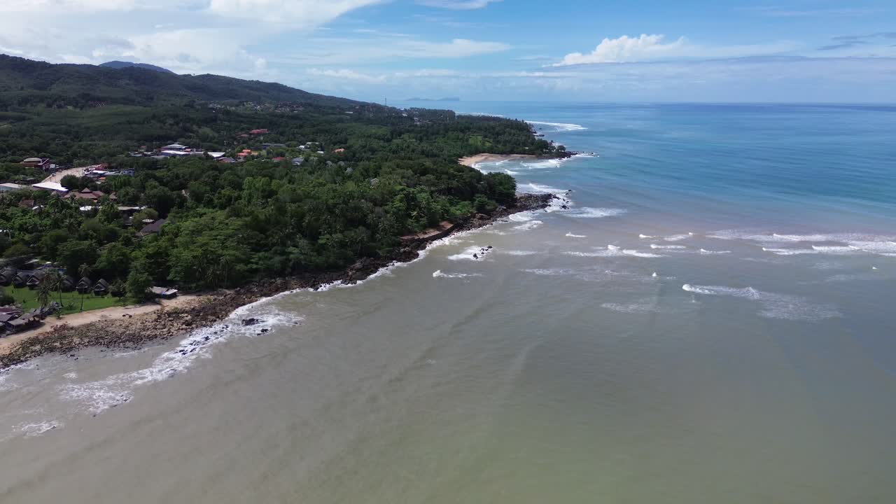 Aerial drone footage of Koh Lanta, Thailand, showing tropical forest, lush mountains, coastline and turquoise sea with natural island scenery and serene tropical landscape