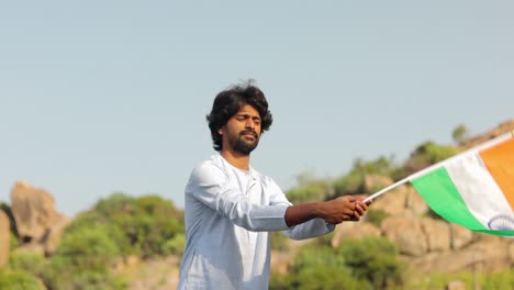 The-young-man-with-traditional-Indian-dress-waving-Indian-Flag-on-a-sunny-day