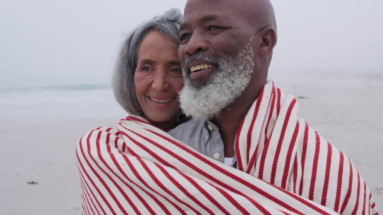 Mature couple enjoying time outside by the sea