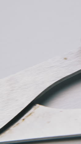new open metal scissors with black plastic handles lie on white background extreme close view
