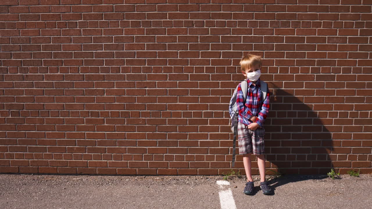햇볕이 잘 드는 학교 운동장에서 얼굴을 가리고 있는 어린 소년의 초상화