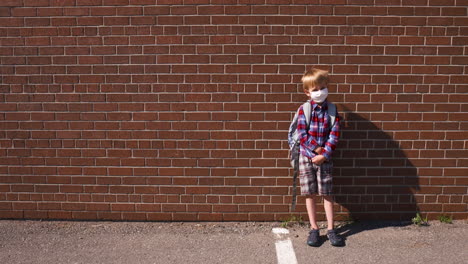 Porträt-Eines-Kleinen-Jungen-Mit-Gesichtsbedeckung-Auf-Einem-Sonnigen-Schulhof