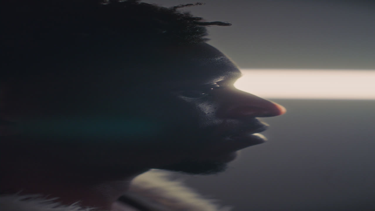 Side Profile of Black Man Lying Down under Strong Light Beam