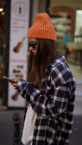 young woman using smartphone on city street