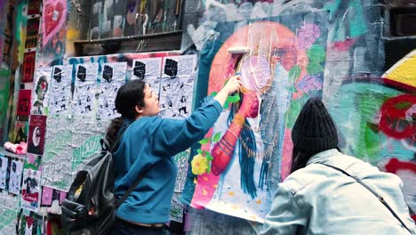 dos personas pintando un mural de arte callejero vibrante