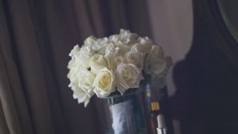 bridal bouquet of white roses on dressing table in hotel room in the morning